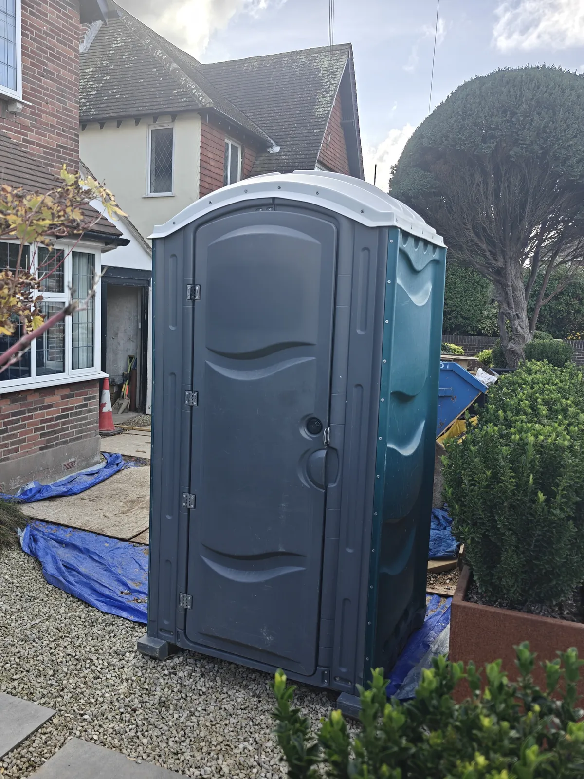 One of our site toilets on the drive of a house being renovated, between box hedges