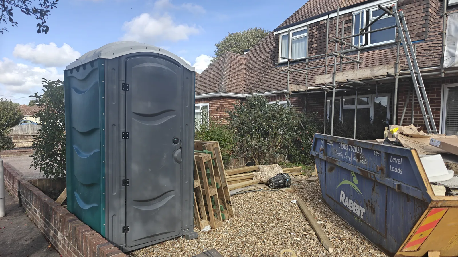 One of our site toilets in a front garden while the house behind is under scaffolding
