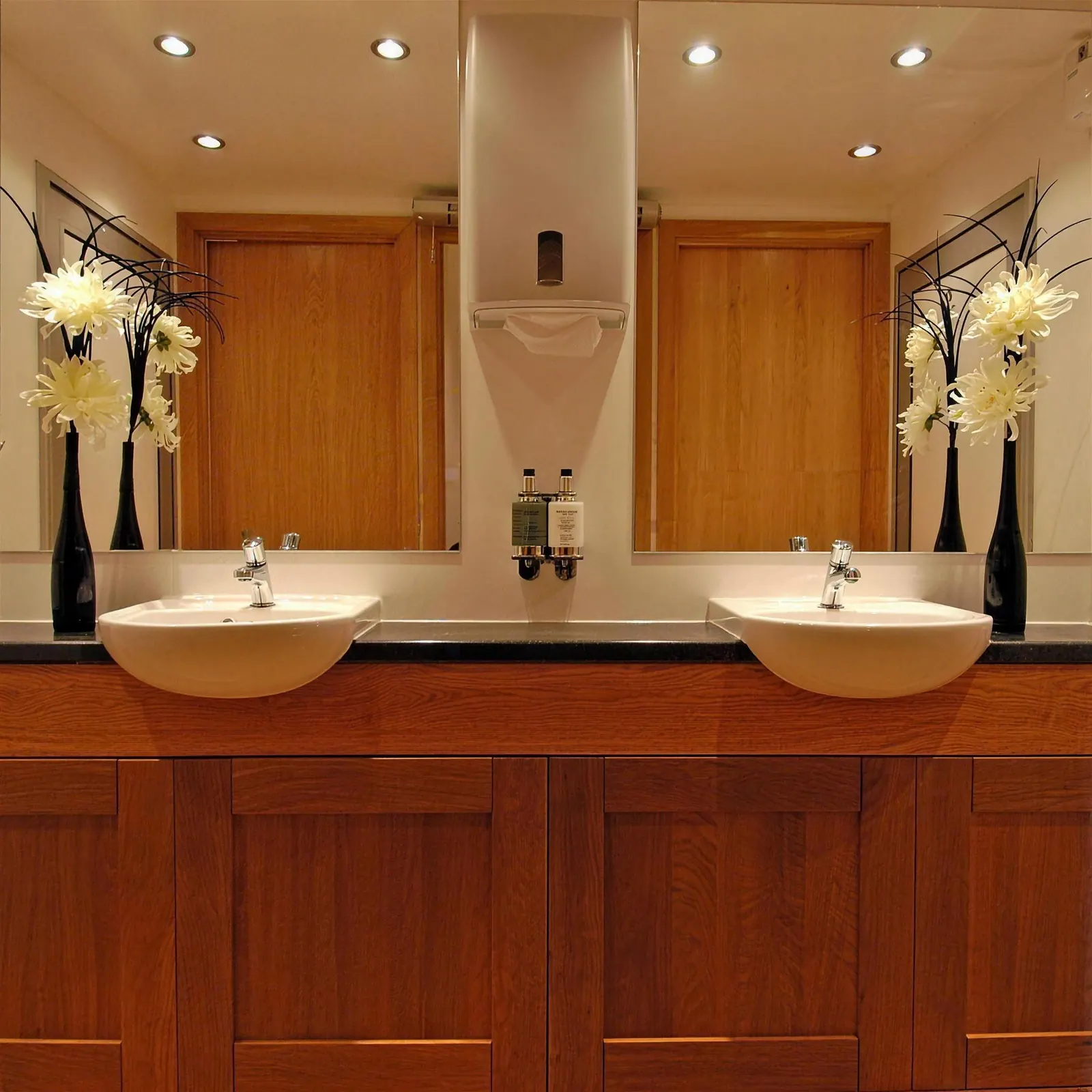 Twin basins with mirrors, soap and flowers inside a luxury trailer